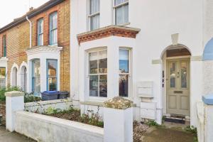 a white house with a green door on a street at Host & Stay - Sail Away in Whitstable