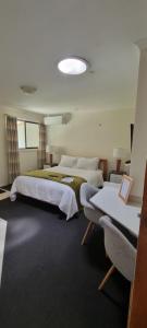 a large bedroom with two beds and a couch at Bird Songs Getaway Accommodation in Cabbage Tree Creek