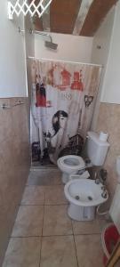 a bathroom with a toilet and a shower curtain at Departamento Reconquista in Villa María +18 photos