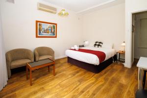 a bedroom with a bed and a table and a chair at BIG4 Cape Jervis Accommodation & Caravan Park in Cape Jervis