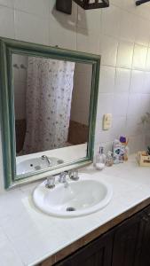 lavabo en el baño con un espejo grande encima. en Loren House en Luján de Cuyo
