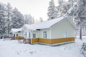 Una casa blanca con nieve encima. en Lucky Lodge, en Pyhätunturi