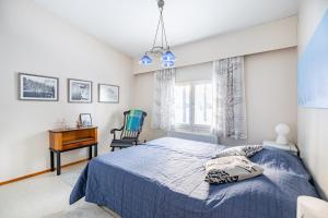 1 dormitorio con cama azul y escritorio en Lucky Lodge, en Pyhätunturi