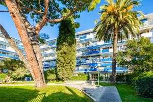 een appartementencomplex met palmbomen en een pad bij Studio tout confort in Cagnes-sur-Mer