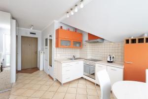 uma cozinha com armários laranja e electrodomésticos brancos em Apartament Grójec em Grójec