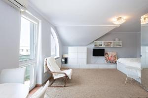 a bedroom with a bed and a chair and a window at Apartament Grójec in Grójec