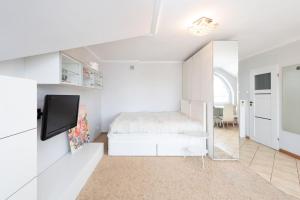 um quarto branco com uma cama e uma televisão em Apartament Grójec em Grójec