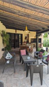 un patio con mesas y sillas bajo un techo de madera en Loren House en Luján de Cuyo
