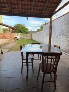 einen Tisch und zwei Stühle auf einer Terrasse in der Unterkunft Casa para 6 + piscina, in Rio Grande