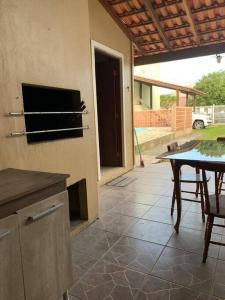 eine Küche mit einem Tisch und einem Esszimmer in der Unterkunft Casa para 6 + piscina, in Rio Grande
