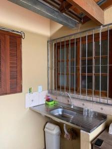 eine Küche mit einem Waschbecken und einem Fenster in der Unterkunft Casa para 6 + piscina, in Rio Grande