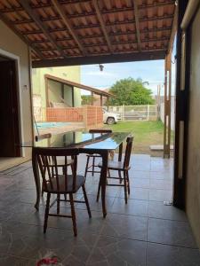 einen Esstisch und Stühle auf der Terrasse in der Unterkunft Casa para 6 + piscina, in Rio Grande