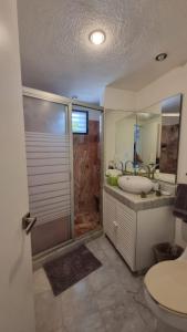 a bathroom with a tub and a sink and a shower at Villas La Marina in Cancún