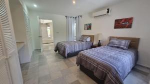 a bedroom with two beds and a hallway at Villas La Marina in Cancún