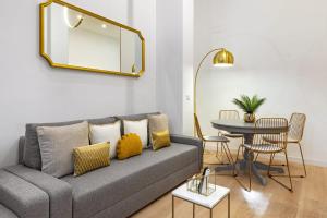 ein Wohnzimmer mit einem Sofa und einem Tisch in der Unterkunft Smart Apartment Near Puerta Del Sol in Madrid