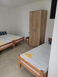 Cette chambre comprend 2 lits et une armoire en bois. dans l'établissement Adamovic, à Pirot