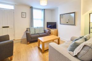 uma sala de estar com um sofá e cadeiras e uma televisão em Host & Stay - Prospect Place em Canterbury