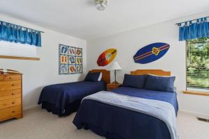 a bedroom with two beds with blue sheets and a window at 1965 Benson in Cambria