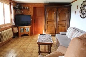 ein Wohnzimmer mit einem Sofa und einem Tisch in der Unterkunft Chalet Le Slalom in Arveyes