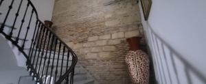 un escalier avec un mur en briques et un escalier dans l'établissement Hostal Fenix, à Jerez de la Frontera