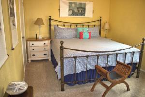 a bedroom with a bed with a wooden frame and a chair at 2116 Windsor Blvd. Marine Terrace in Cambria