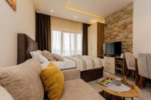 um quarto de hotel com uma cama e um sofá em Apartman Stankovic Milmari Resort em Kopaonik