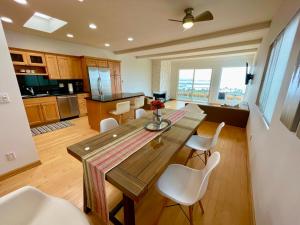 a kitchen and dining room with a wooden table and chairs at Mod2bd2ba ShowstoprViews. BBQ. Garage. in San Pedro