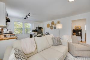 Modern Milledgeville Getaway Walk to Downtown! في ميلدغفيل: غرفة معيشة مع أريكة بيضاء ومطبخ