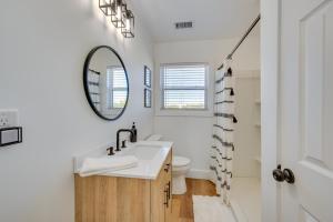 La salle de bains blanche est pourvue d'un lavabo et d'un miroir. dans l'établissement Central Milledgeville Cottage with Covered Balcony!, à Milledgeville
