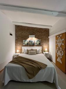 1 dormitorio con 1 cama grande y pared de ladrillo en Cabin studio Cerca del mar - José Ignacio, en José Ignacio
