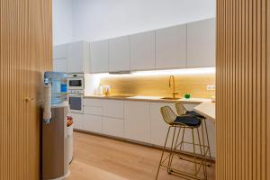 eine Küche mit weißen Schränken und einem Barhocker in der Unterkunft Smart Apartment Near Puerta Del Sol in Madrid