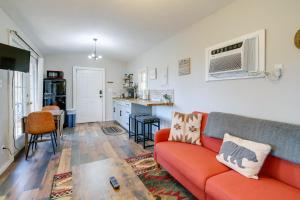 a living room with a red couch and a kitchen at Cozy Hope Cabin Vacation Rental in Cosby with View in Cosby