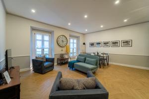 sala de estar con sofá, sillas y reloj en Duomo Guest House en Monza