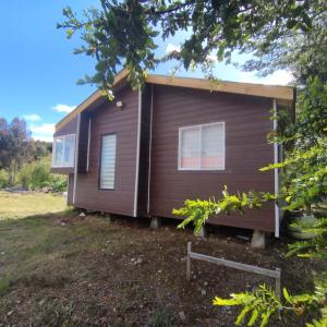 uma pequena casa com revestimento castanho em Cabañas altos de la chacra , 2 dormitorios em Castro