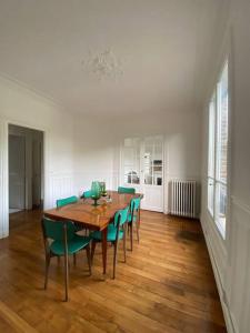 uma sala de jantar com uma mesa de madeira e cadeiras verdes em Le Cœur de l’Île Saint-Louis, you will love it! em Paris