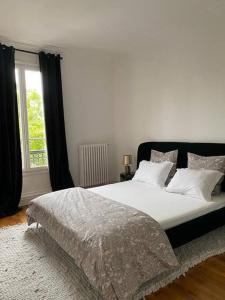 um quarto com uma grande cama branca e uma janela em Le Cœur de l’Île Saint-Louis, you will love it! em Paris