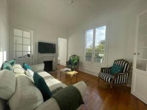 a living room with a white couch and a fireplace at Le Cœur de l’Île Saint-Louis, you will love it! in Paris