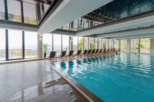 una piscina con sillas en un edificio con ventanas en Apartman Stankovic Milmari Resort, en Kopaonik