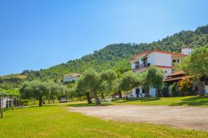 una carretera en un pueblo con árboles y una montaña en Pension Assos, en Koinira 26 fotos más