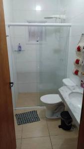 La salle de bains est pourvue d'une douche, de toilettes et d'un lavabo. dans l'établissement Casa com piscina perto da praia, à Caraguatatuba