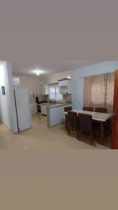 - une cuisine et une salle à manger avec une table et des chaises dans l'établissement Casa com piscina perto da praia, à Caraguatatuba