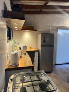 a kitchen with a stove top and a refrigerator at La Luna, casa mágica en sierras! in Villa Serrana