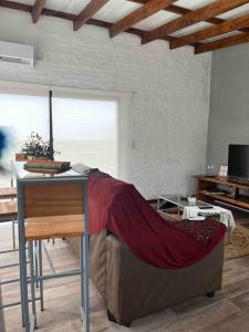 Habitación con mesa y sofá con manta en La Luna, casa mágica en sierras!, en Villa Serrana