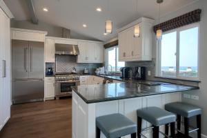 a kitchen with white cabinets and a large island with stools at 5398 Nottingham in Cambria