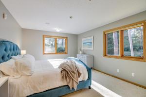 um quarto com uma cama azul e uma janela em Peaceful Hibbing Getaway Heated Floors, Fire Pit! em Hibbing