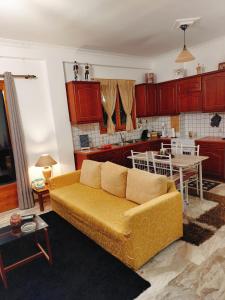 Una sala de estar con un sofá amarillo y una mesa. en Dimitris & Despoinas Guest House, en Tripolis