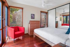 a bedroom with a bed and a red chair at Riverview in Warrnambool