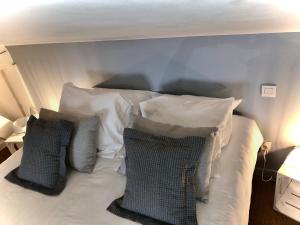 a bed with four pillows on top of it at La loge des Salinières in Bordeaux