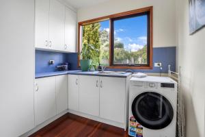 a kitchen with a washing machine and a window at Riverview in Warrnambool