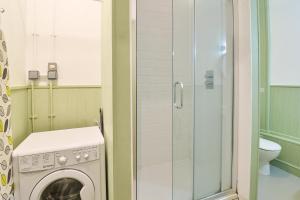 eine Waschmaschine im Bad mit Dusche in der Unterkunft Host & Stay - The Cabin in Canterbury